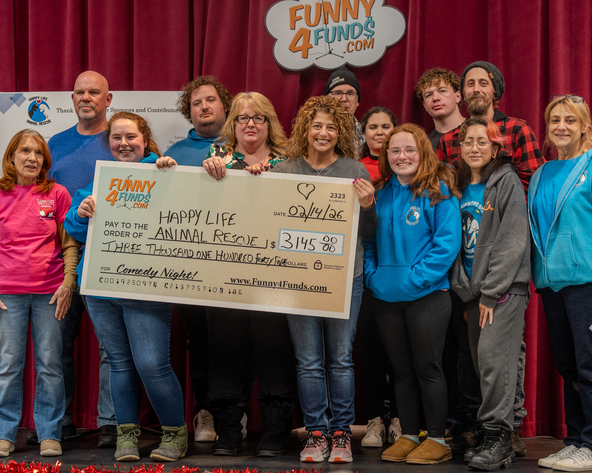 Happy Life Animal Rescue team holding a fundraiser donation check